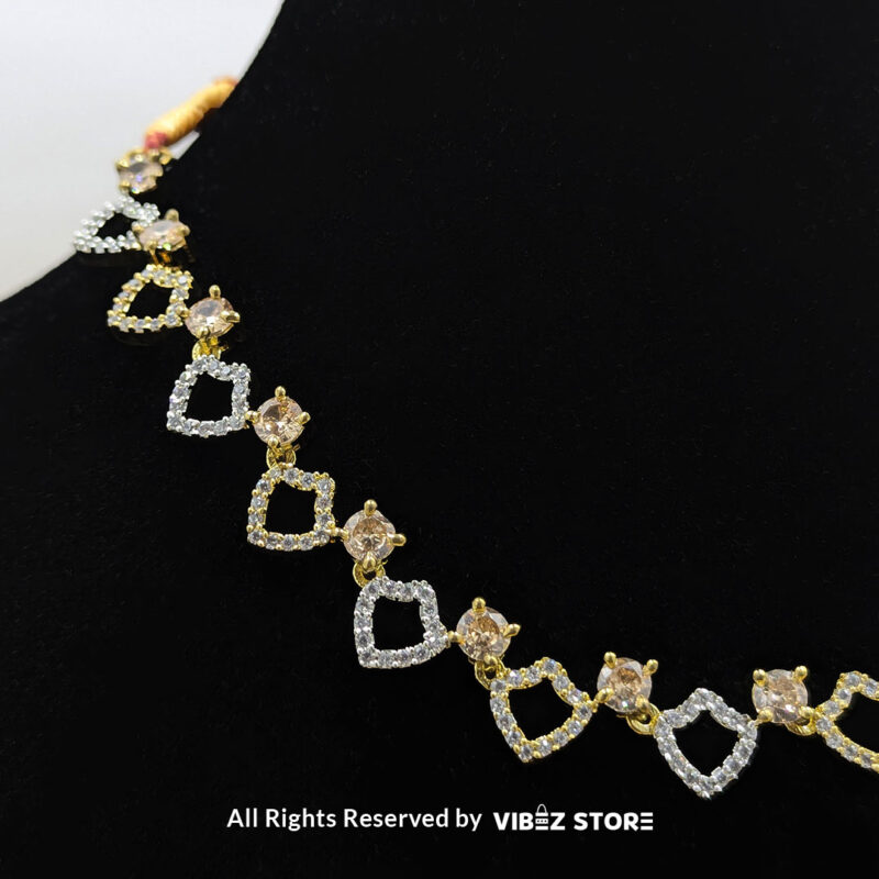 Heart Design Necklace Set with Earrings 4 Heart-shaped necklace set with sparkling stones and matching earrings, displayed on a black mannequin with a golden fabric backdrop.
