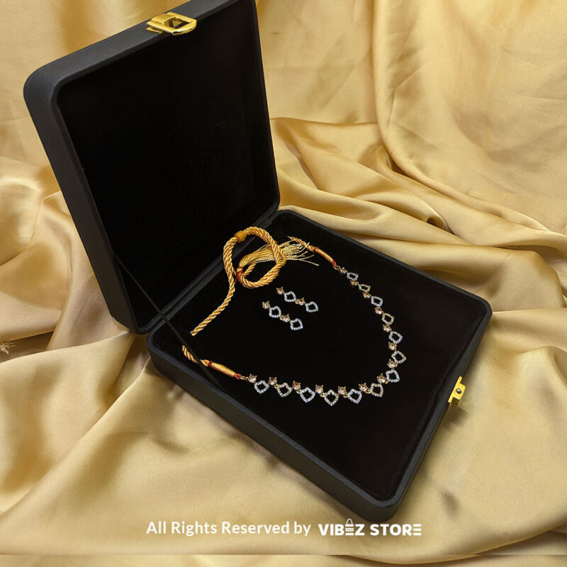 Heart Design Necklace Set with Earrings 3 Heart-shaped necklace set with sparkling stones and matching earrings, displayed on a black mannequin with a golden fabric backdrop.