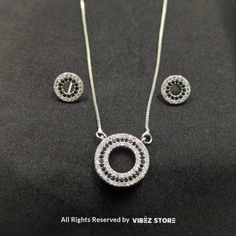 Silver Round Pendant Jewelry Set 1 Silver round pendant jewelry set with a delicate chain necklace and matching circular stud earrings, adorned with cubic zirconia stones.