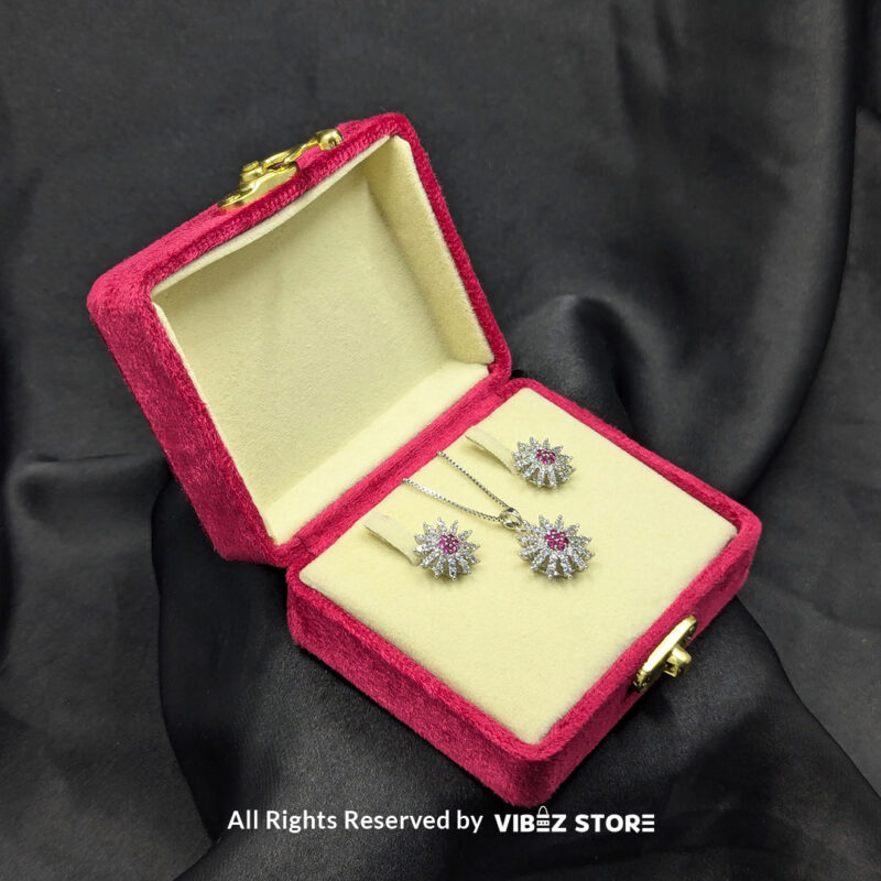 Ruby Bloom Sunflower Pendant and Earrings Set 2 Ruby sunflower jewelry set with a sparkling pendant and earrings featuring ruby-colored accents on a sleek black backdrop.