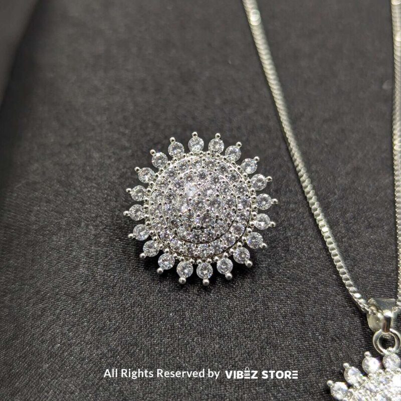 Radiant Starburst Pendant and Earrings Set 3 Starburst-shaped pendant and matching earrings adorned with shimmering crystals, displayed on a sleek black fabric.