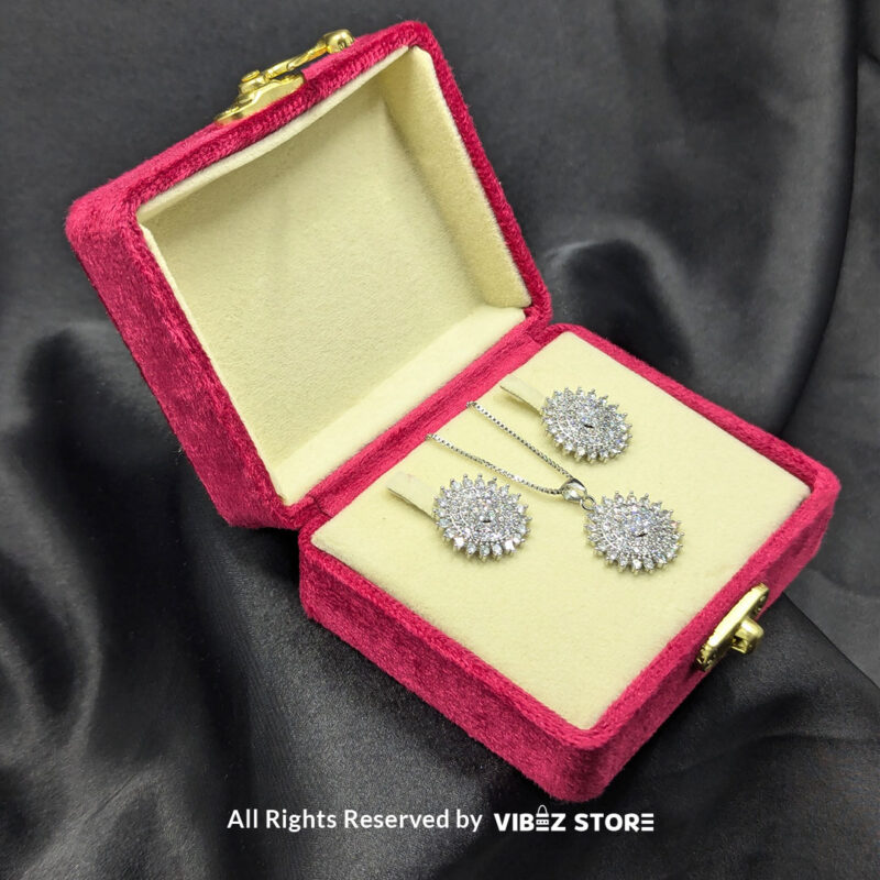Radiant Starburst Pendant and Earrings Set 4 Starburst-shaped pendant and matching earrings adorned with shimmering crystals, displayed on a sleek black fabric.