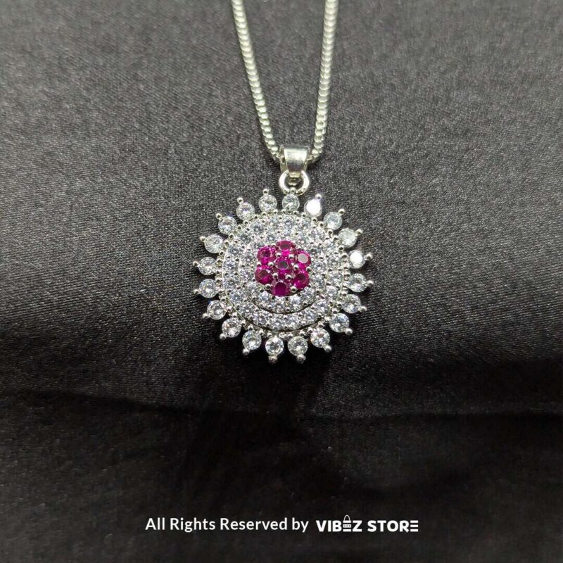 Ruby Starburst Pendant and Earrings Set 2 Ruby starburst pendant with matching earrings, featuring shimmering crystals and a vibrant ruby centerpiece, displayed on a sleek black fabric.
