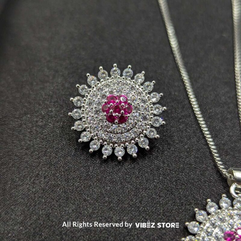 Ruby Starburst Pendant and Earrings Set 4 Ruby starburst pendant with matching earrings, featuring shimmering crystals and a vibrant ruby centerpiece, displayed on a sleek black fabric.