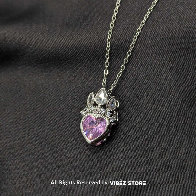 Crown Heart Locket with Pink Gemstone 2 Crown heart locket with a pink gemstone centerpiece and intricate silver crown detailing.