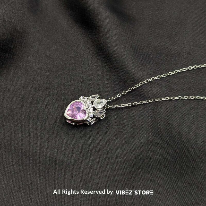 Crown Heart Locket with Pink Gemstone 1 Crown heart locket with a pink gemstone centerpiece and intricate silver crown detailing.