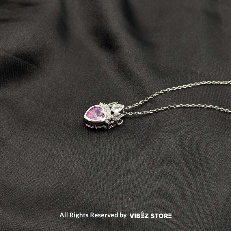 Crown Heart Locket with Pink Gemstone 3 Crown heart locket with a pink gemstone centerpiece and intricate silver crown detailing.