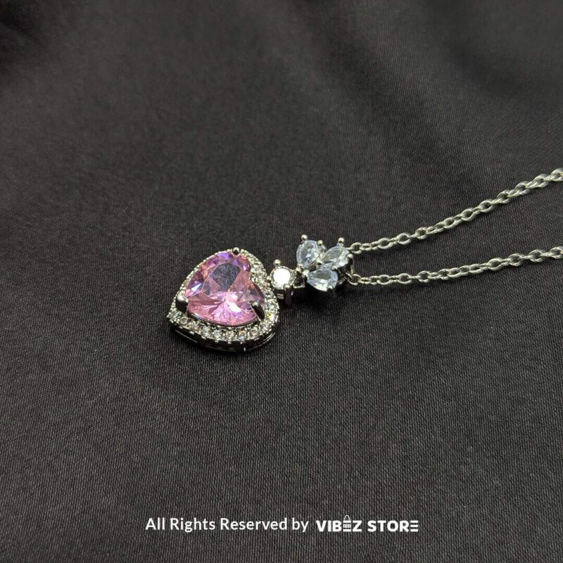 Heart Blossom Locket with Pink Gemstone 1 Elegant heart-shaped locket with a pink gemstone and silver floral detailing, perfect for gifting or personal use.