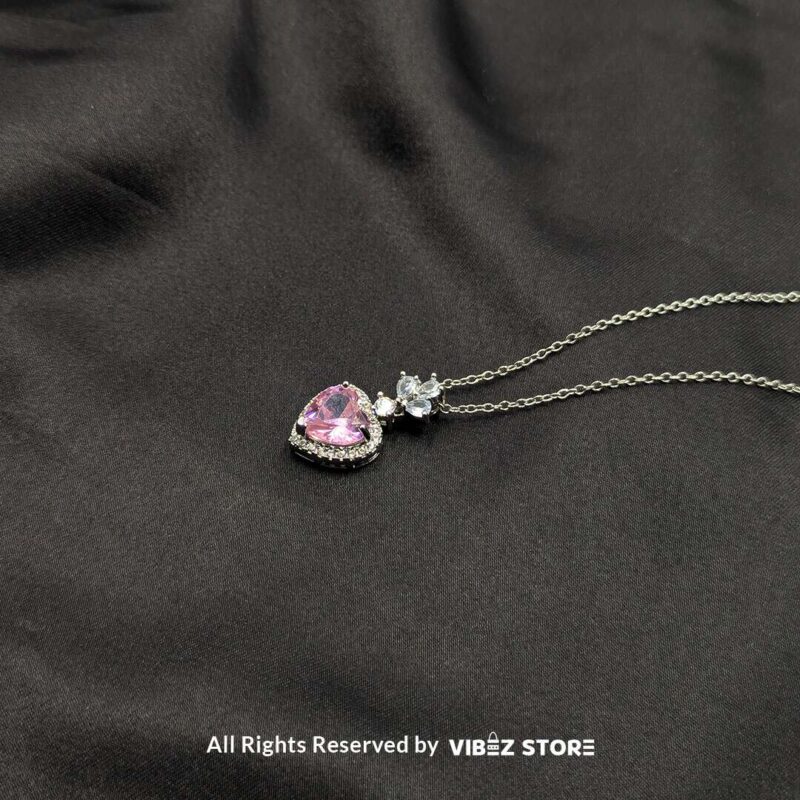 Heart Blossom Locket with Pink Gemstone 2 Elegant heart-shaped locket with a pink gemstone and silver floral detailing, perfect for gifting or personal use.