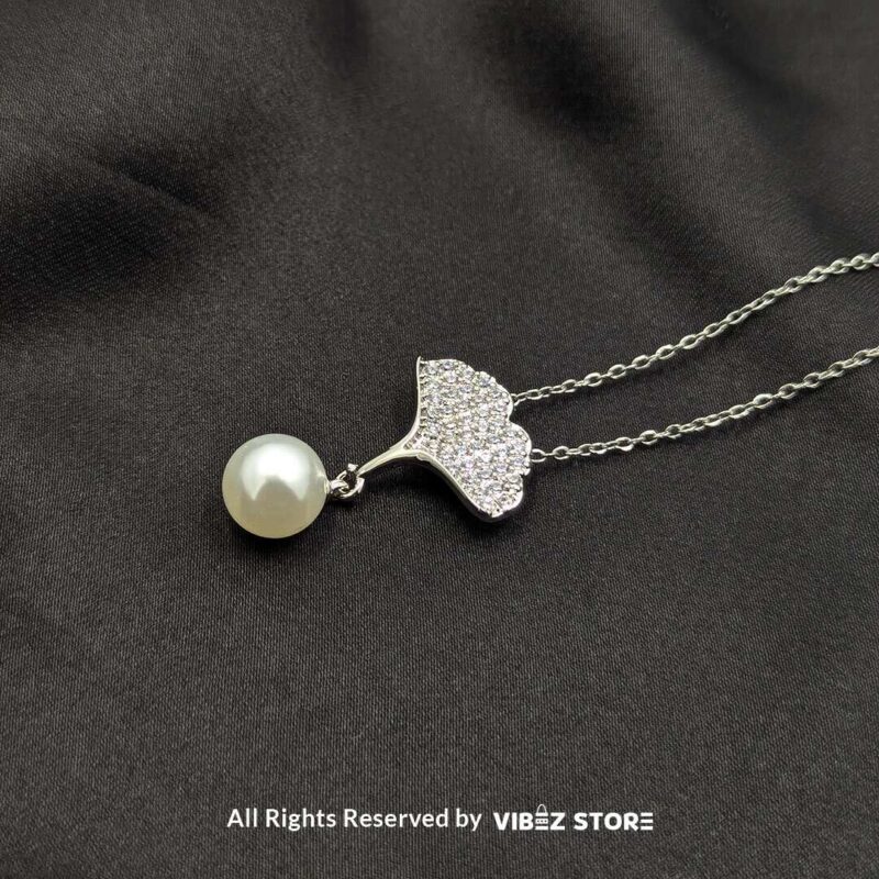 Elegant Pearl Drop Leaf Locket 2 A silver locket featuring a sparkling leaf design with a pearl drop, perfect for adding elegance to any outfit.