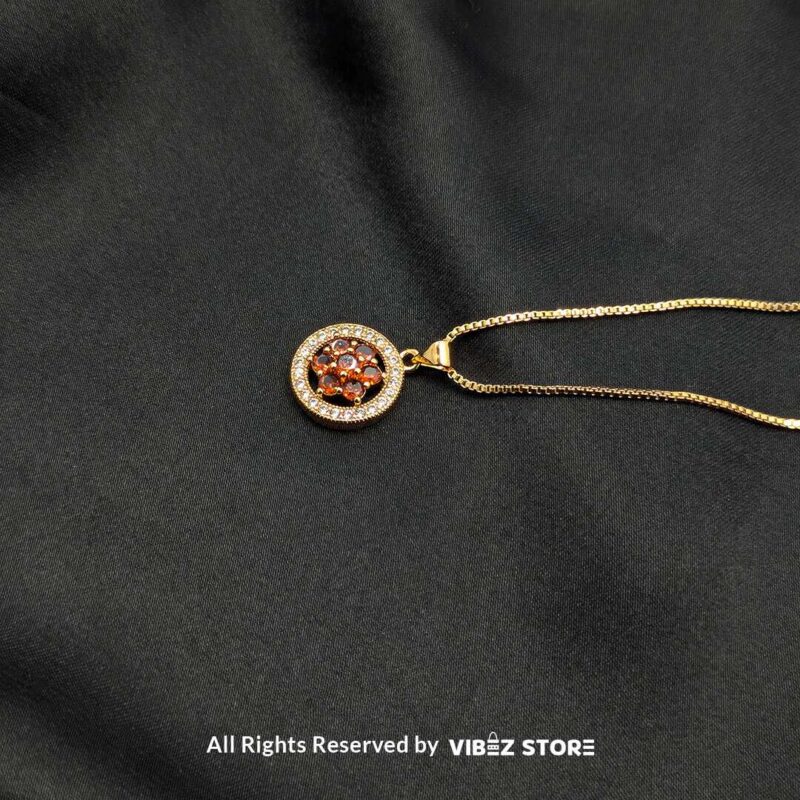 Floral Gemstone Round Locket with Crystal Halo 2 Three round lockets featuring floral gemstone designs (black, amber, and red) surrounded by crystal halos, displayed with gold-tone and silver-tone chains on a black fabric background.