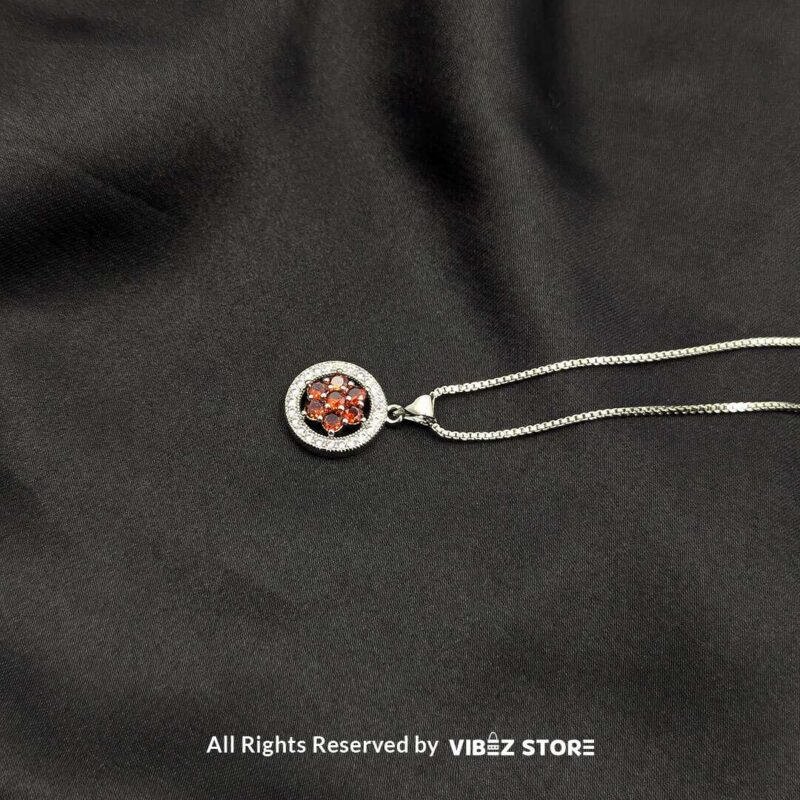 Floral Gemstone Round Locket with Crystal Halo 3 Three round lockets featuring floral gemstone designs (black, amber, and red) surrounded by crystal halos, displayed with gold-tone and silver-tone chains on a black fabric background.