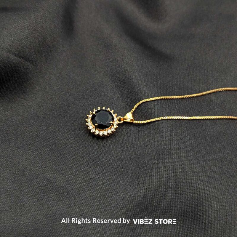 Round Gemstone Locket with Crystal Halo 2 Three round gemstone lockets with crystal halos, displayed on gold-tone and silver-tone chains against a black fabric background.