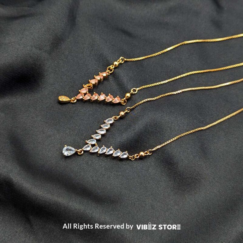 Heart Crystal V-Shaped Lockets - Sophisticated Jewelry 1 Three heart crystal V-shaped lockets in rose-gold, white-silver, and gold tones elegantly displayed on a black fabric background.