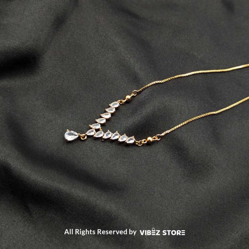 Heart Crystal V-Shaped Lockets - Sophisticated Jewelry 3 Three heart crystal V-shaped lockets in rose-gold, white-silver, and gold tones elegantly displayed on a black fabric background.