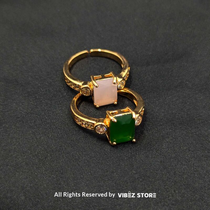Gold-Plated Adjustable Rings with Stone Accents 1 Gold-plated adjustable rings with rectangular pink and green stones, featuring side embellishments and a stylish design.