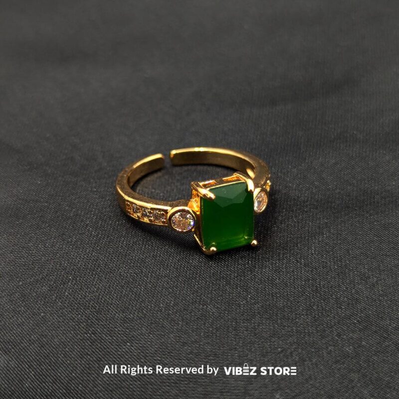 Gold-Plated Adjustable Rings with Stone Accents 3 Gold-plated adjustable rings with rectangular pink and green stones, featuring side embellishments and a stylish design.