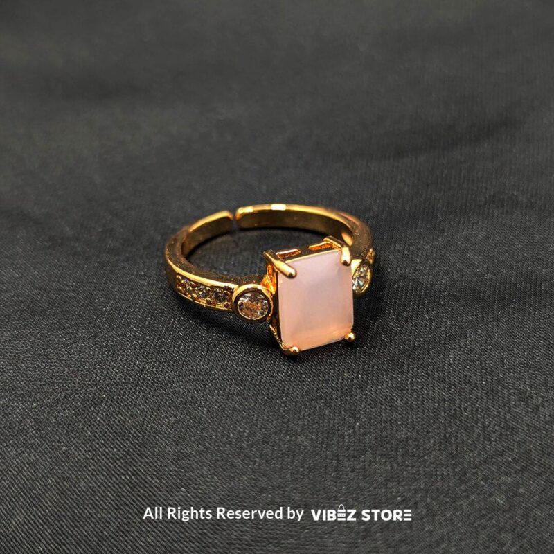 Gold-Plated Adjustable Rings with Stone Accents 2 Gold-plated adjustable rings with rectangular pink and green stones, featuring side embellishments and a stylish design.