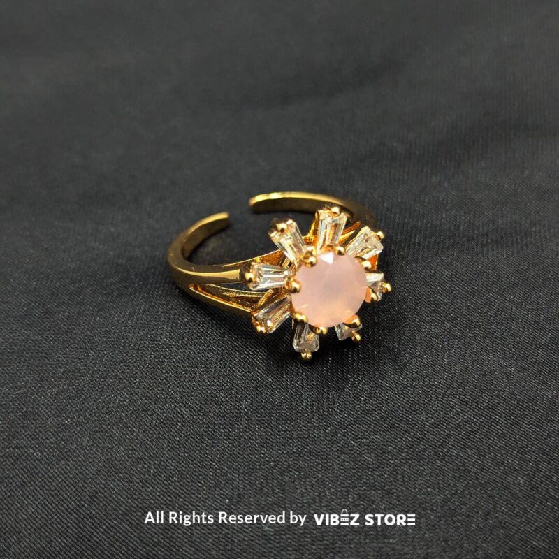 Blossom Halo Gold-Tone Ring with Crystal Accents 1 Gold-tone ring featuring a soft pink center stone with a halo of baguette crystals, a floral-inspired design from Vibez Store.