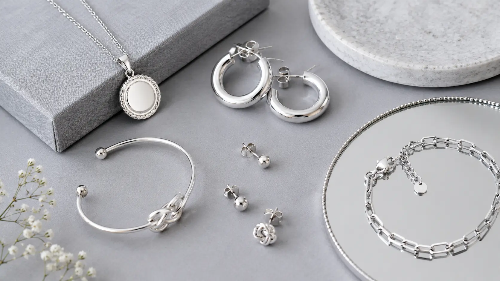 Best Jewellery Gifts for Women in Pakistan 4 Modern silver jewellery including hoops pendants and bracelet displayed in editorial setup