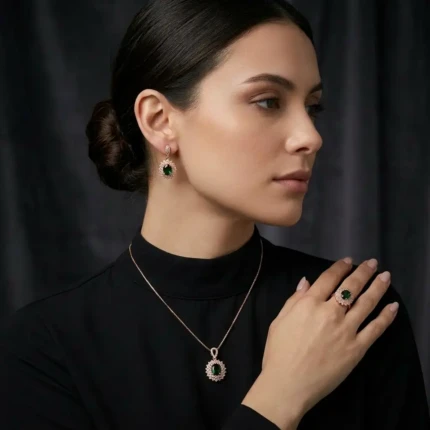 Model wearing emerald green jewellery set with matching earrings pendant necklace and ring