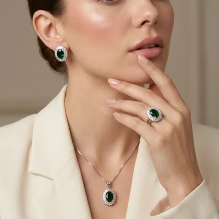 Model wearing emerald green silver jewellery set with earrings necklace and ring