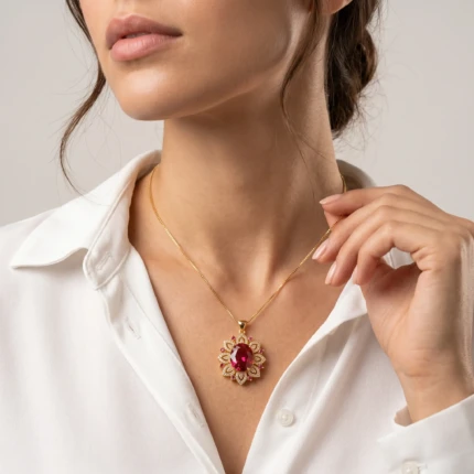 Model wearing ruby red gold floral pendant necklace with white shirt