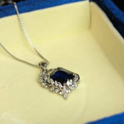 Silver blue stone pendant necklace with crystal style leaf detail