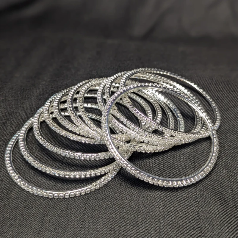 Silver Crystal Bangle Set for Women 2 Silver crystal bangles set with sparkling rhinestone style stones spread on black fabric