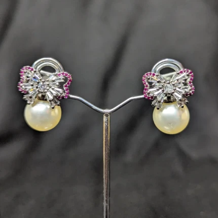 Silver pearl bow earrings with pink accent stones and pearl style drops