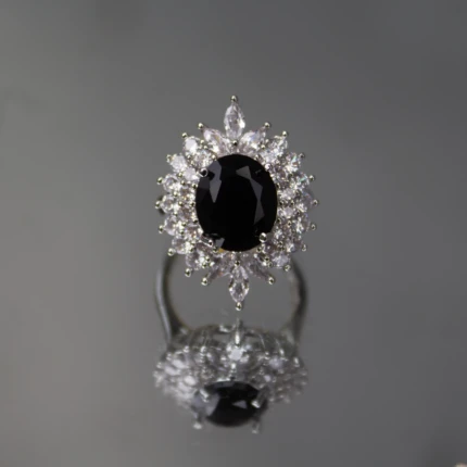 Front view of silver-tone ring with large black oval centre stone and clear crystals