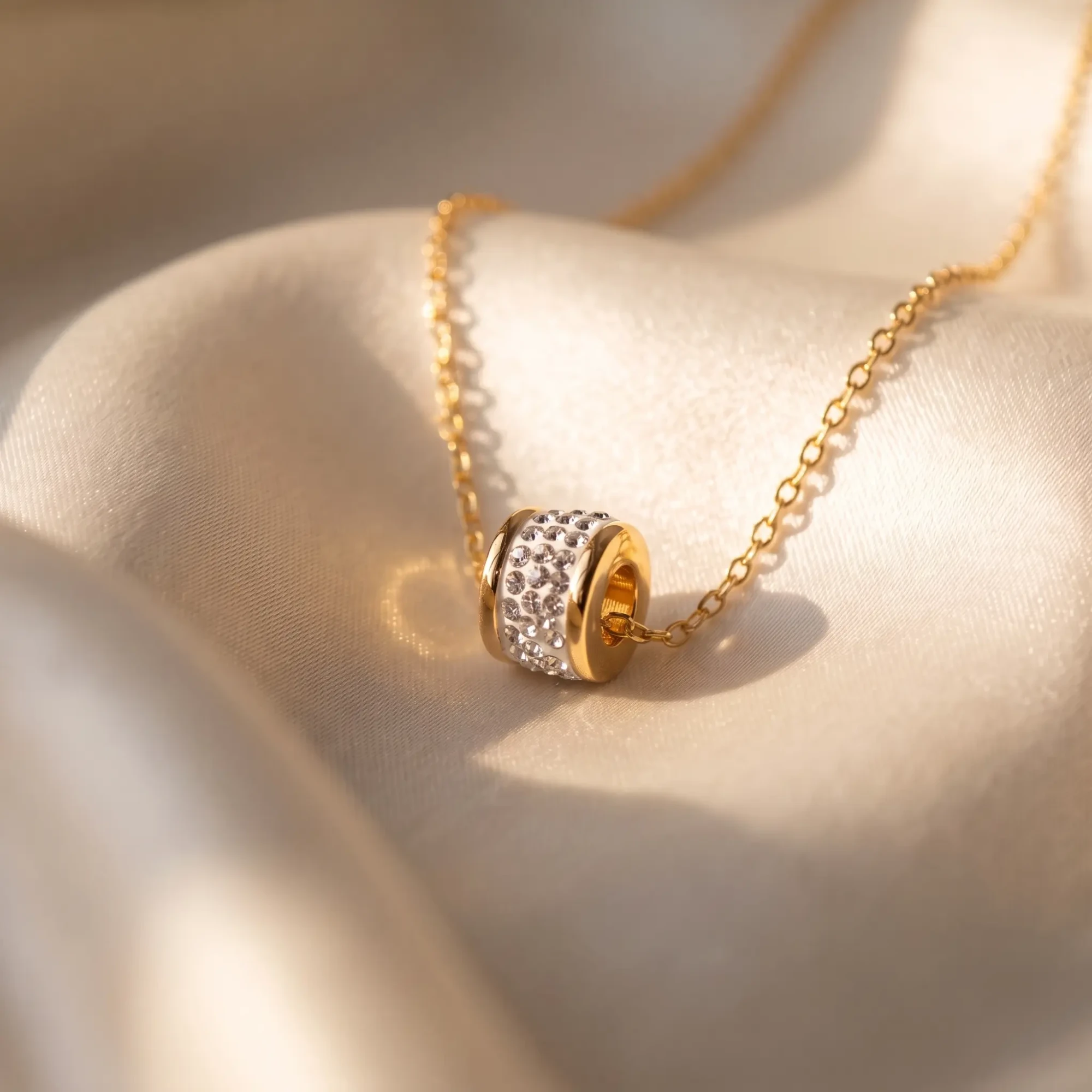 Gold-Tone Crystal Barrel Pendant Necklace Gold-tone barrel pendant necklace with clear crystals displayed on satin fabric