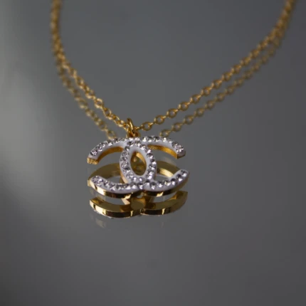 Close-up of gold-tone interlocking pendant with clear crystal detailing