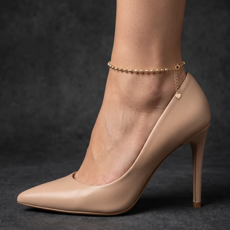 Gold-Tone Textured Beaded Anklet for Women 1 Woman wearing a gold-tone textured beaded anklet with heart charm