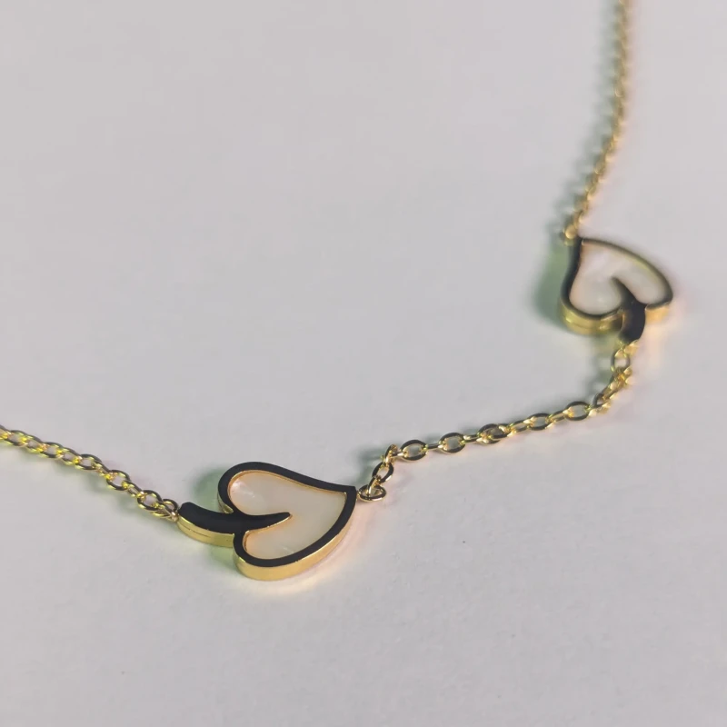 Gold-Tone White Heart Charm Necklace for Women 4 Close-up of gold-tone necklace with white heart-shaped charms
