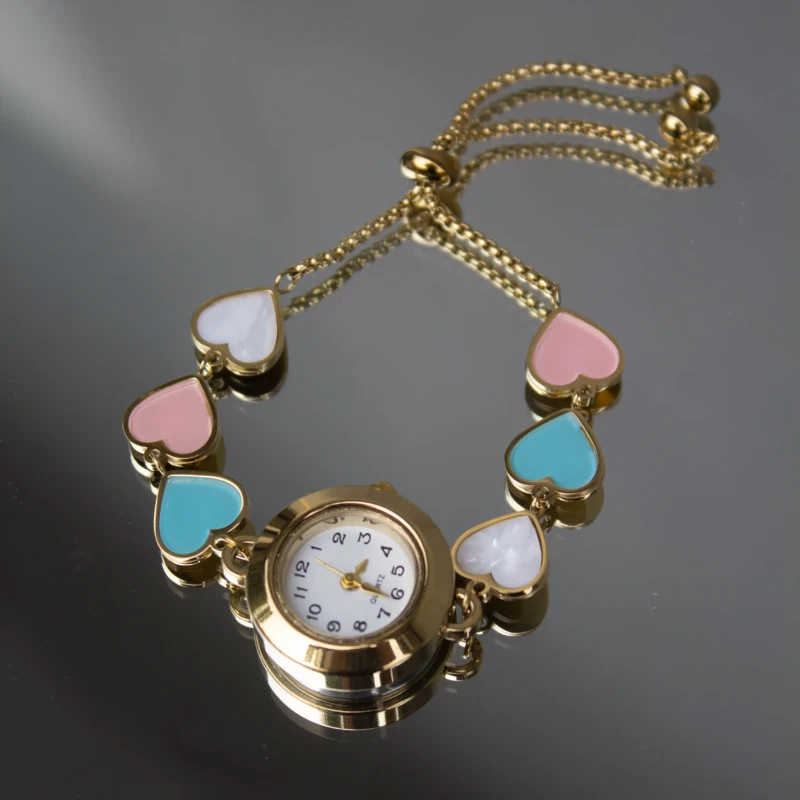 Gold-Tone Multicolor Heart Charm Bracelet Watch for Women 2 Close-up of gold-tone women’s watch with pastel heart charm bracelet