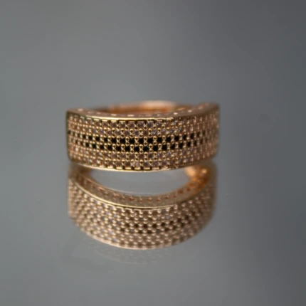 Front view of rose gold-tone wide band ring with black and clear crystal rows