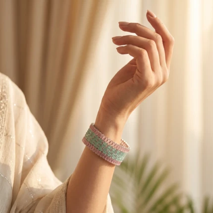 Silver-tone bangle set with pink and aqua crystal detailing worn on a woman’s wrist