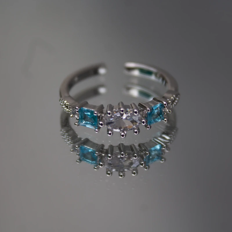 Silver-Tone Blue & Clear Crystal Adjustable Ring for Women 2 Front view of women’s silver-tone ring with oval clear stone and blue side stones
