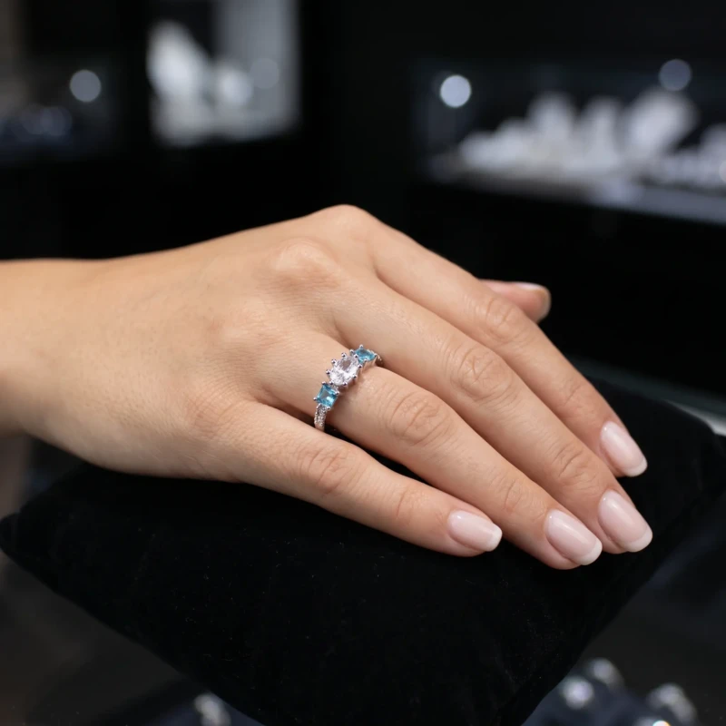Silver-Tone Blue & Clear Crystal Adjustable Ring for Women 1 Woman wearing a silver-tone ring with blue side stones and clear oval centre stone